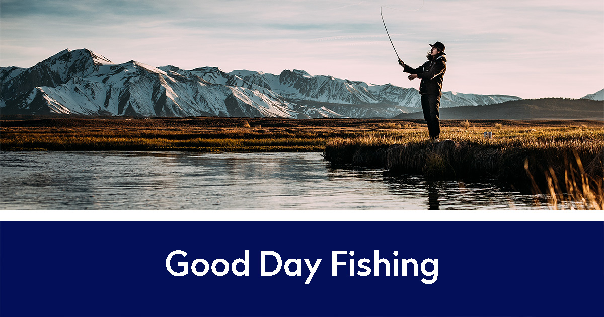 Guy fishing with mountains in the distance