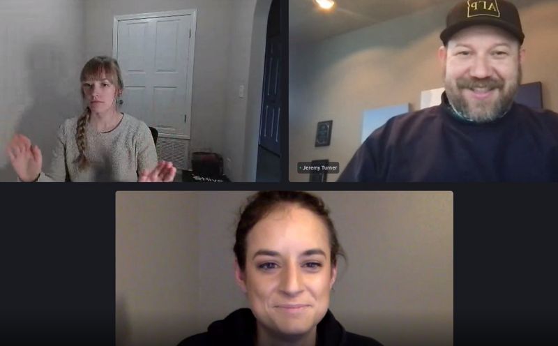 Three people on a zoom call smiling